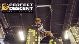 Young boy climbing with a Perfect Descent Auto Belay at a rock climbing gym