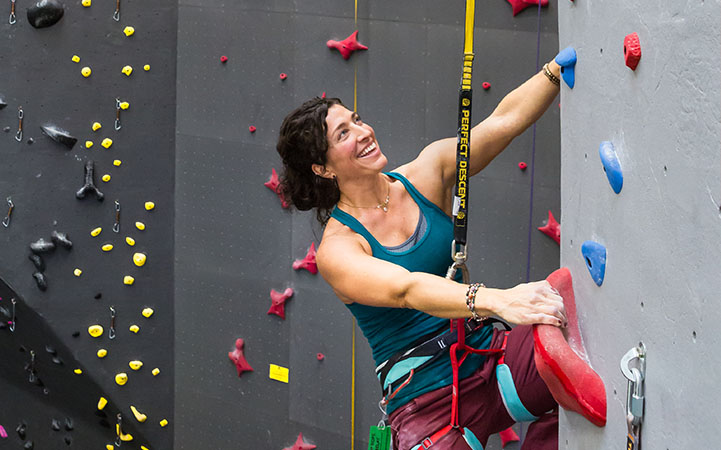 woman-climbing-indoors-smiling-on-perfect-descent-auto-belay