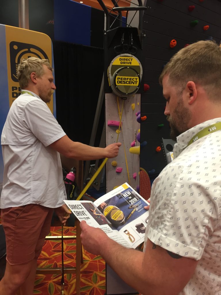 Customers checking out the Perfect Descent Auto Belays at the CWA booth